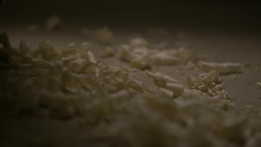 Wood shavings fall slowly on the ground