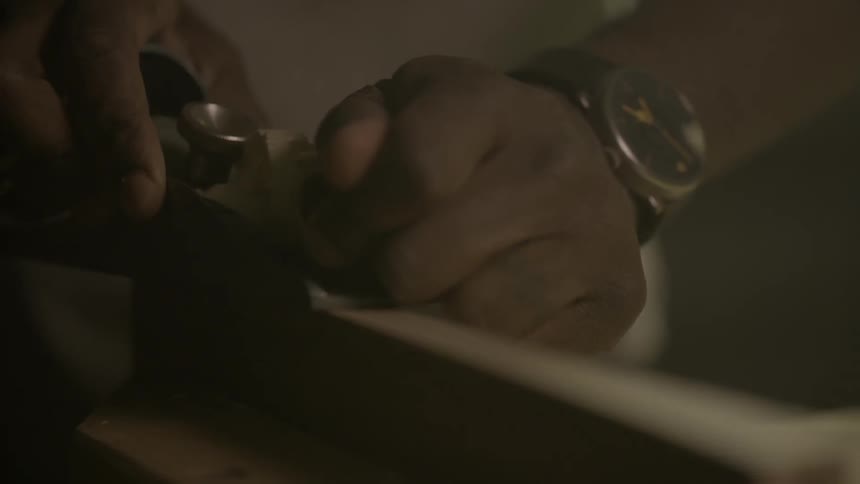 A person is using a tool to shave wood