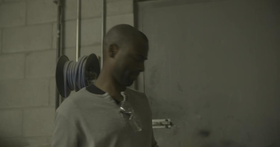 A man entering a workshop and turning on the lights