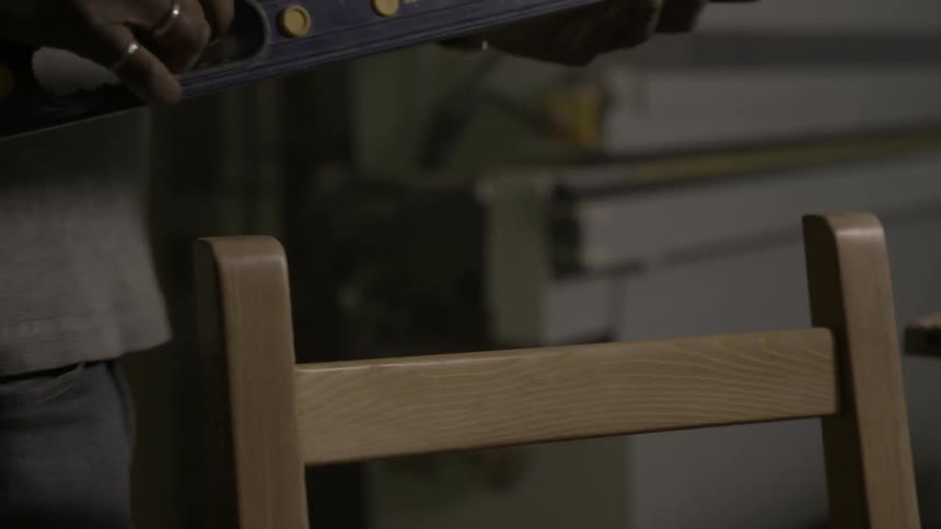 A man uses a level in a workshop