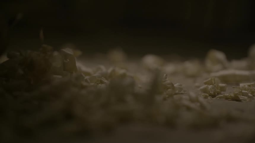 Wood shavings slowly drop on the ground