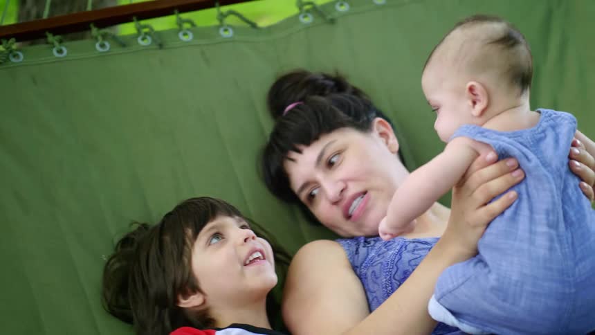 A mother and her children lay in the hammock together