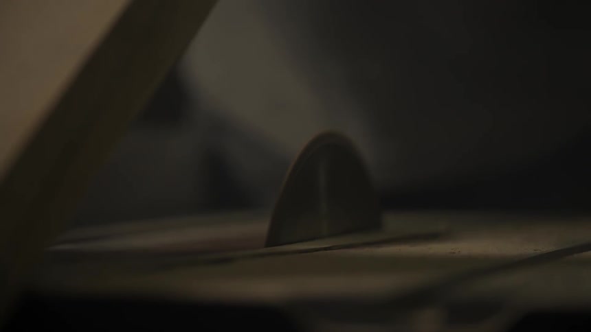A table saw cuts a piece of wood