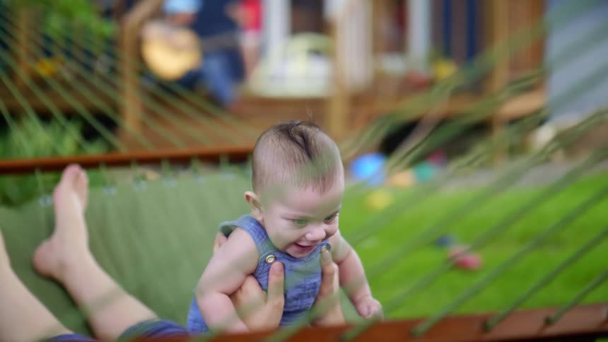 A baby is being lifted up and down in the canopy