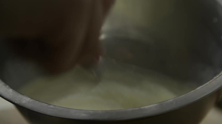 A person is whisking a bowl full of fluid