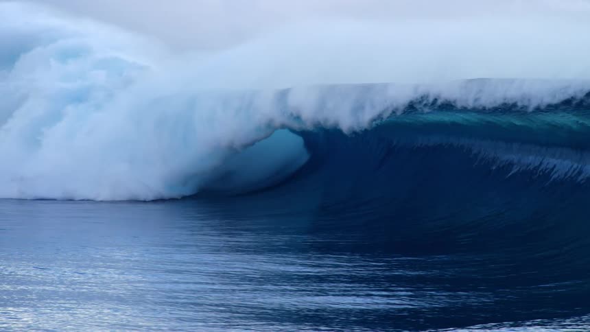 Two people riding on large waves in the ocean