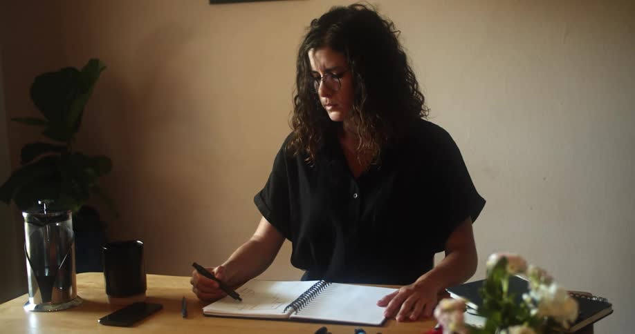 A woman is writing in a notebook