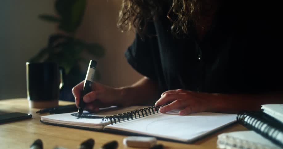 A woman is using a marker in a book