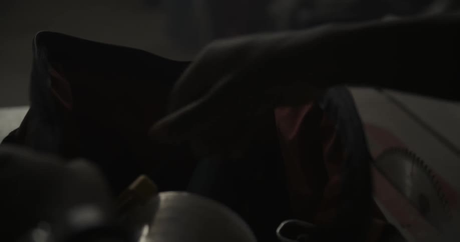 A person opens a bag and removes a tool