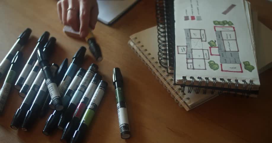 A person reaches for a marker on the desk