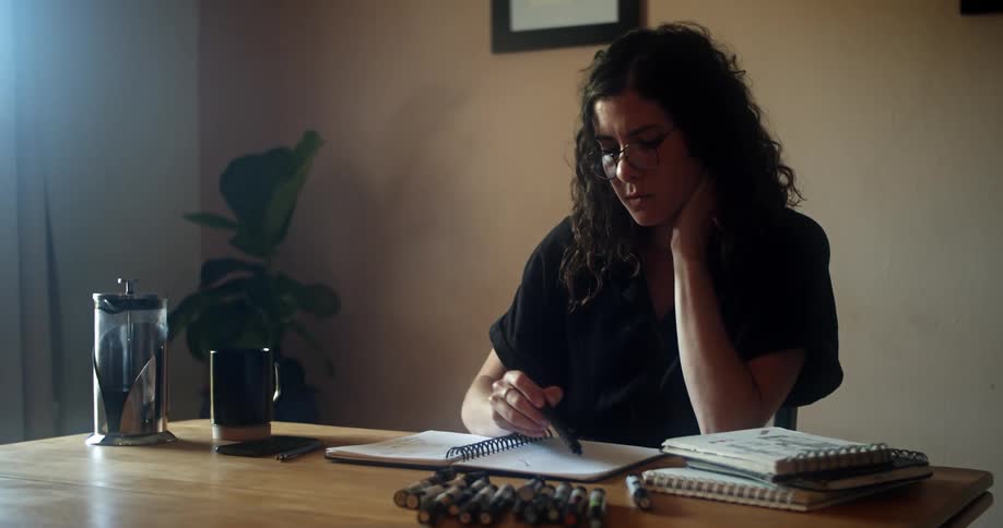 A woman is looking through some books in her office
