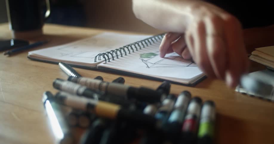 Person draws on sketchpad using colored markers