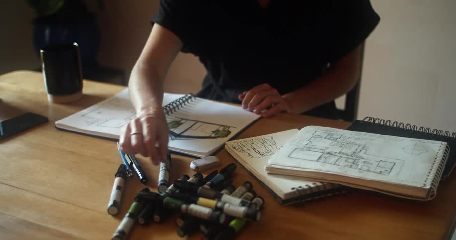 A woman in an office sketches house plans