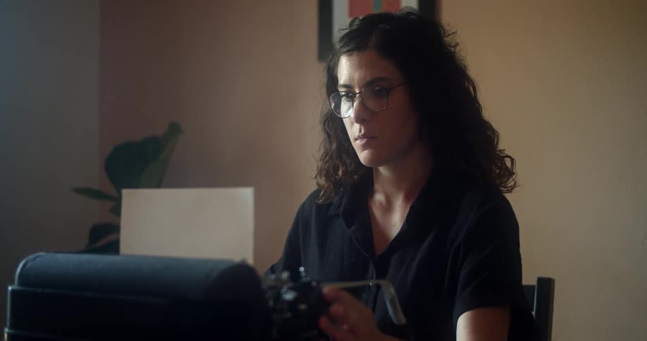 A caucasian female sitting at a desk typing