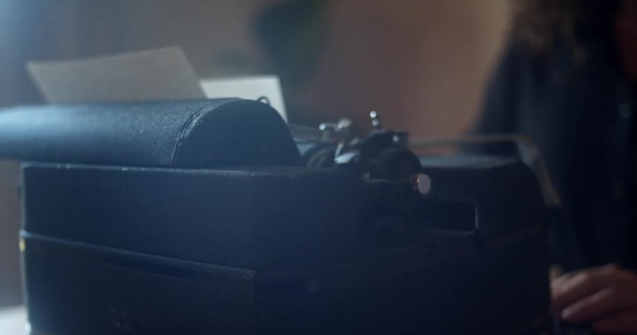 A woman is using a vintage typewriter