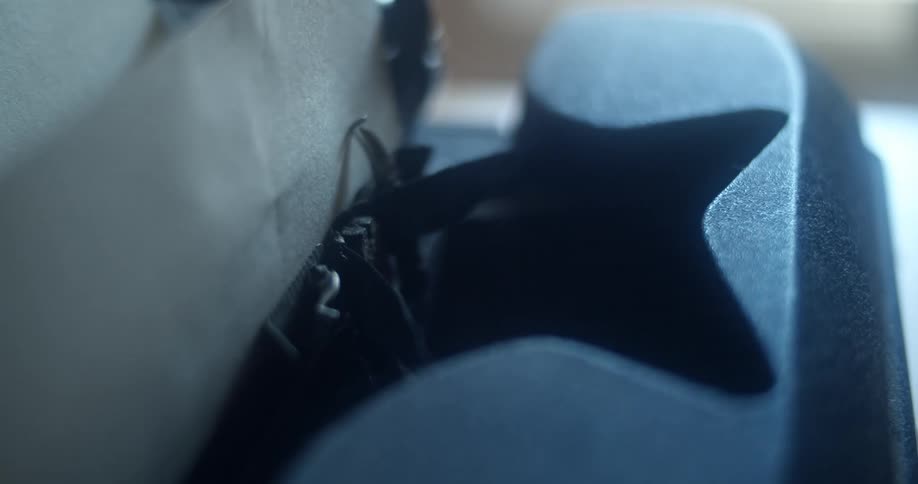 A key hitting ribbon on a vintage typewriter as it types