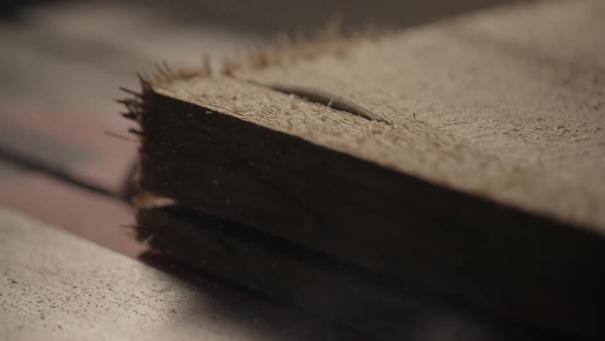A table saw cuts a plank of wood