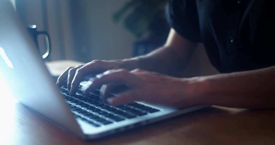 A woman is typing on a laptop
