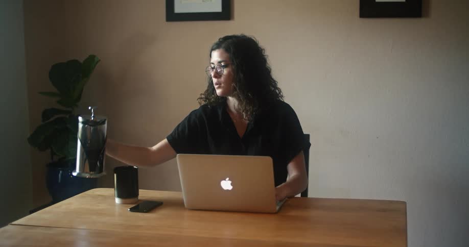 A woman fills her mug at the desk