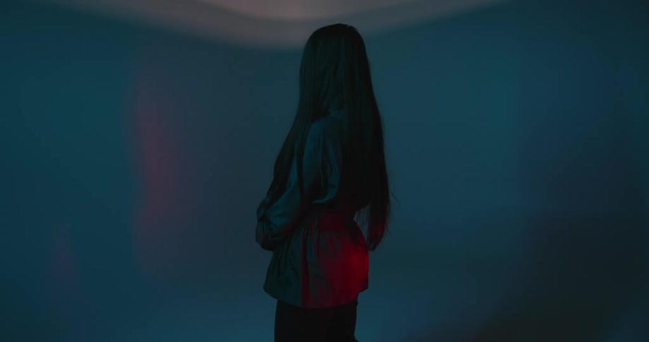 A female standing in a room with a red light flashing