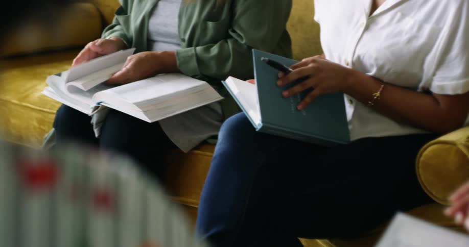 Women look through books together in the room
