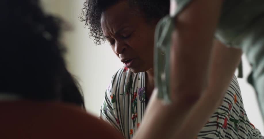 Woman talks with eyes closed while other women lean close