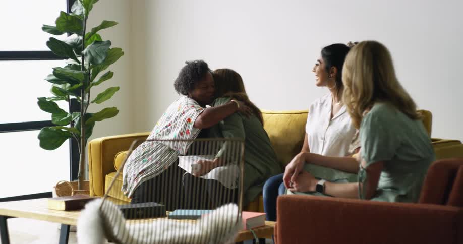A group of women hugging and sitting down on a couch