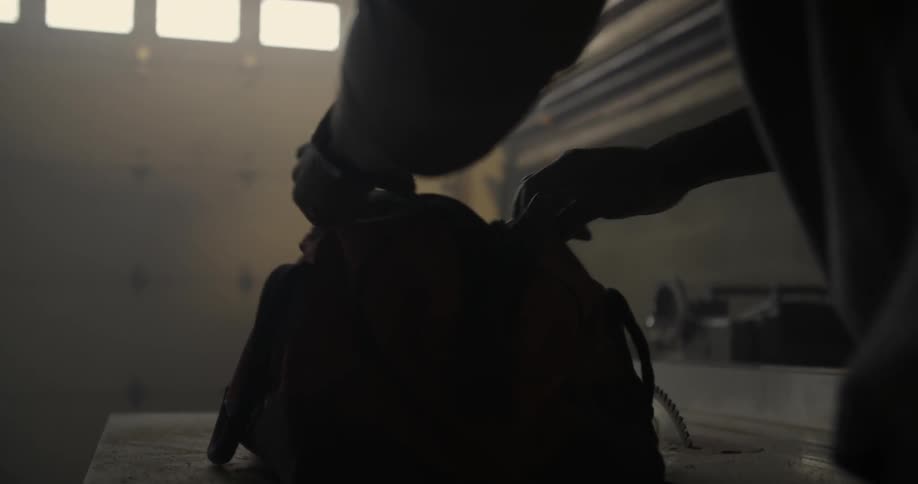 Person unzips and opens duffel bag set on a table