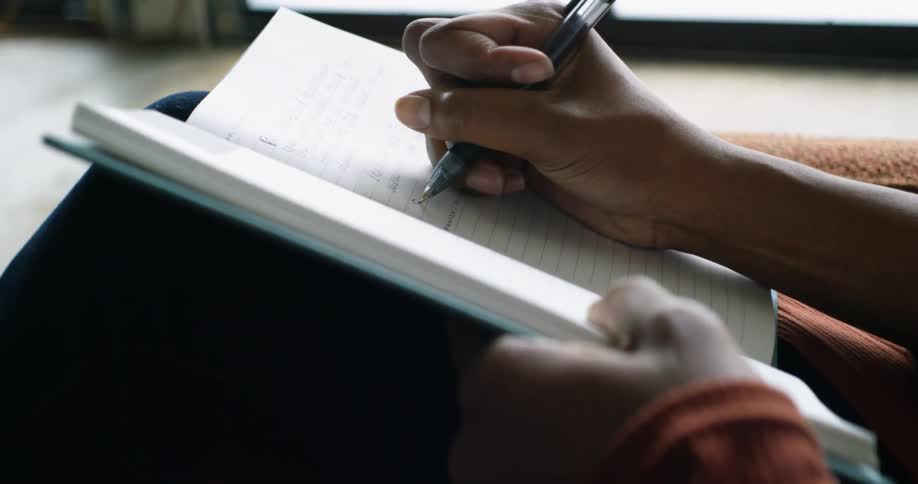 A woman is writing in a journal