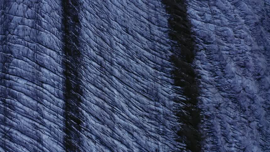 Light blue textured surface with dark rows crossed by lines and dips