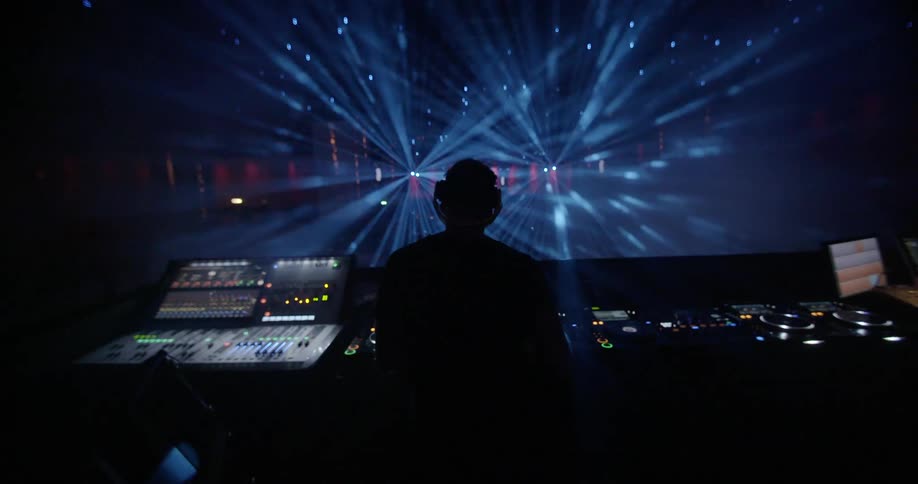 A man controlling a light board at a show
