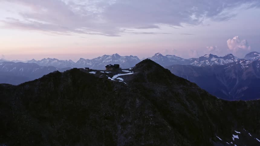An aerial view of a mountain is displayed at dusk