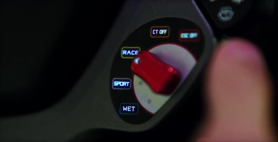 A person pushes a red switch from one setting to another from their cars steering wheel