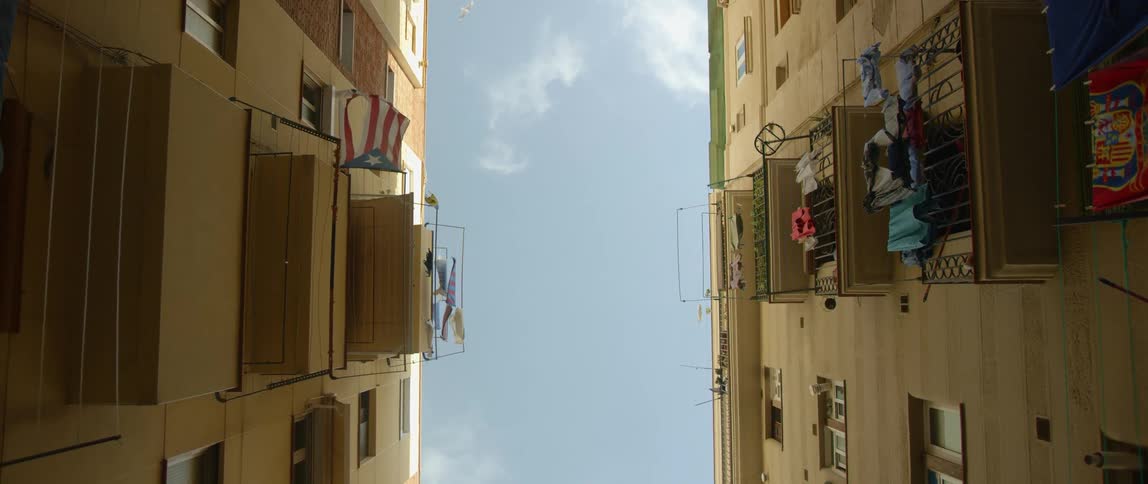 Two buildings with balconies and laundry drying outside