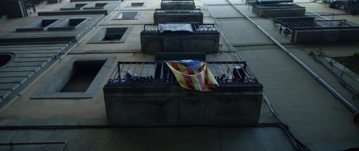 A flag hangs from the balcony of an apartment in the city