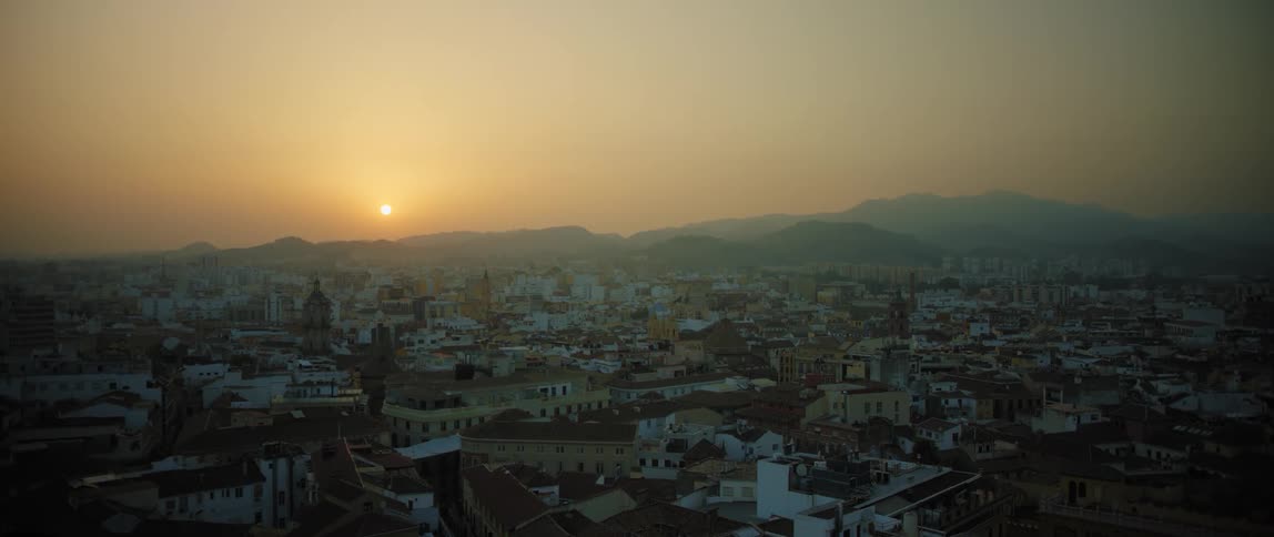 Sun rises over large town in valley