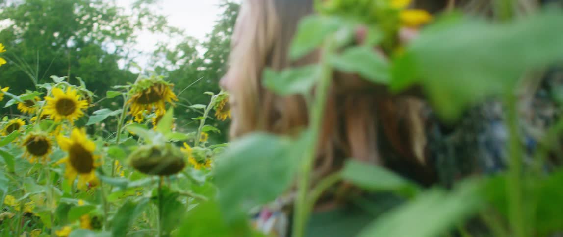 Two girls in a forest area with a lot of sunflowers