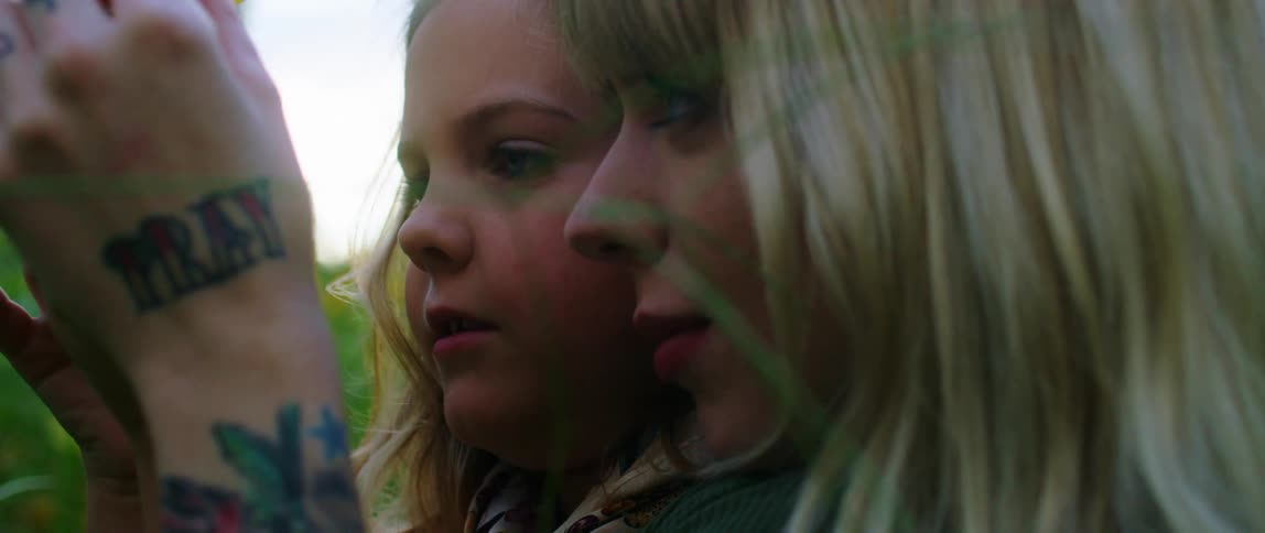 A mother and daughter examine a sunflower