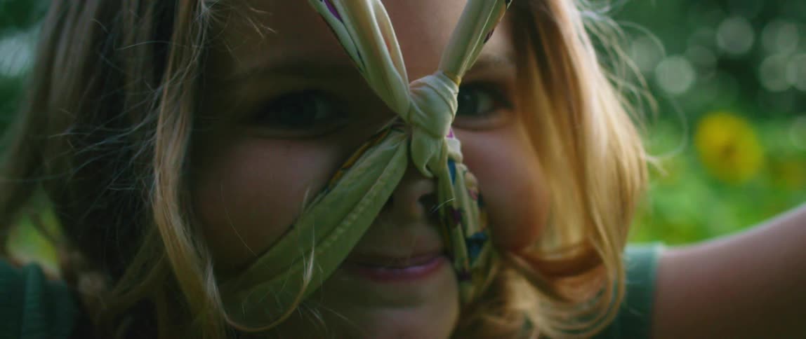 A child playing outside with a scarf around the neck