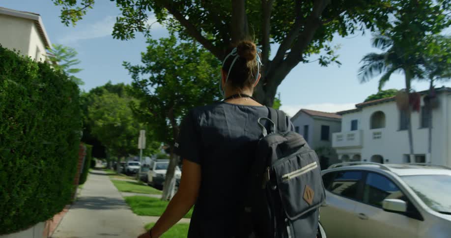 A woman wears a medical mask as she walks in a neighborhood