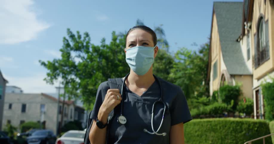 A nurse walks down the neighborhood street