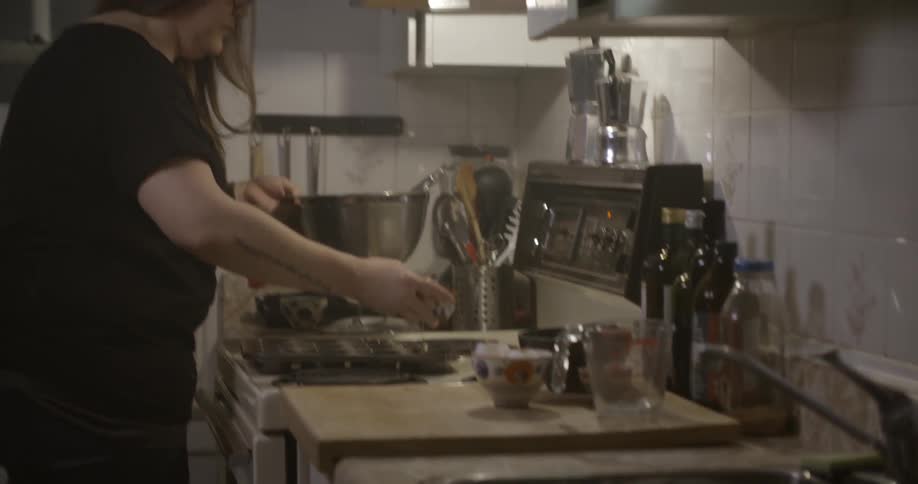 A woman scooping and pouring batter in a muffin tin