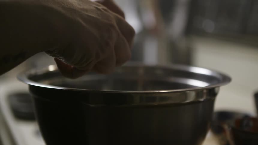Hands crack and egg and pour it into a bowl