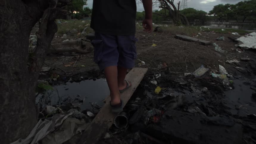 A child walking through an area littered with debris
