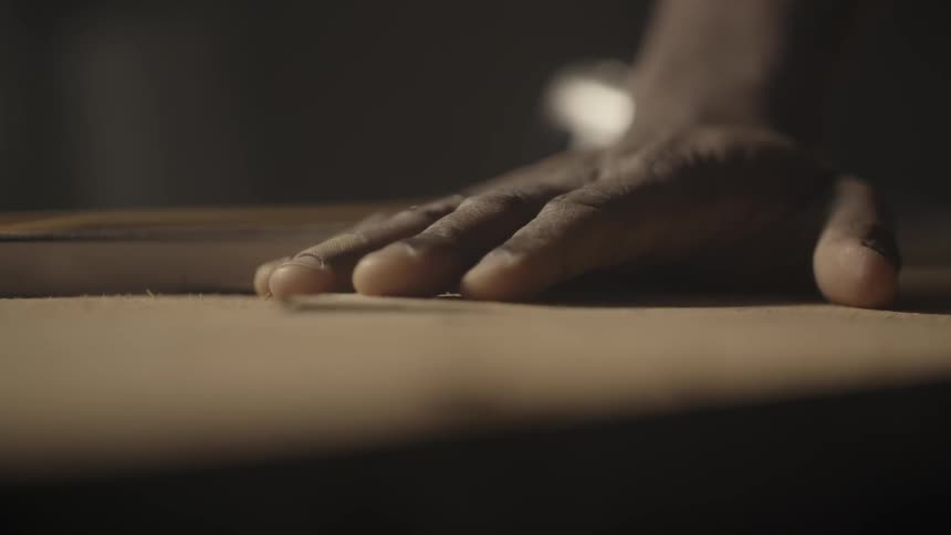 A man has his hand on a table and pulls it away