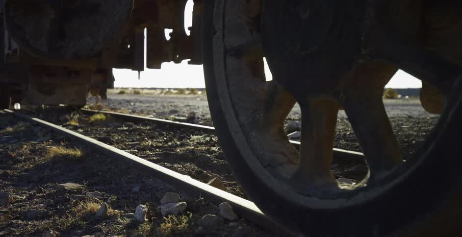 A train is stopped on tracks near a field in a rural area