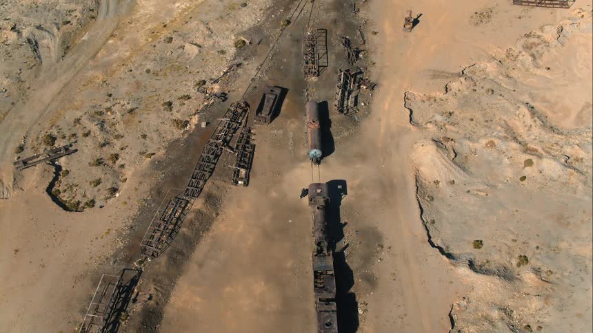 A person rides their motorcycle through the ruins of an old train