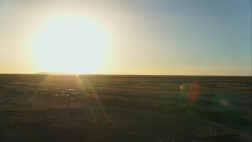 The sun over a field with an old abandoned train