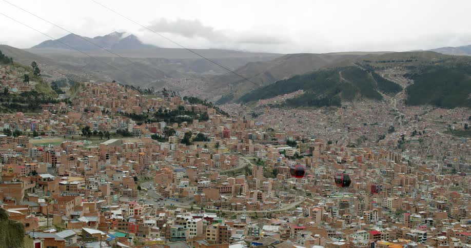 Gondola lifts traveling over a city during the day