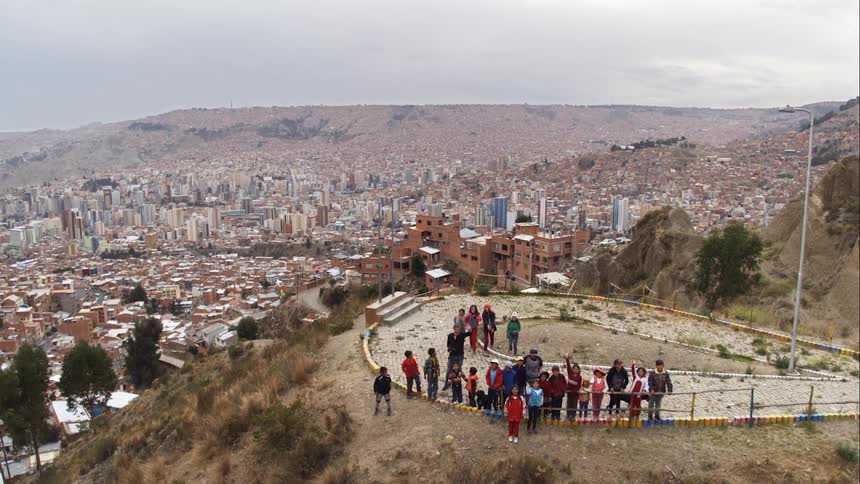 A drone flying above children at a park above a city